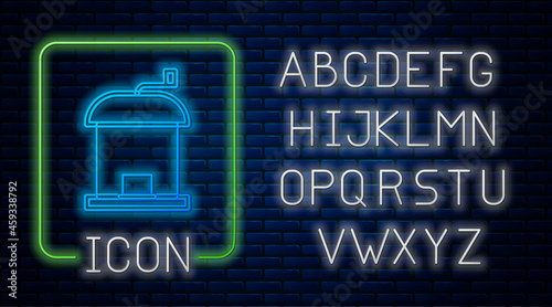Glowing neon Manual coffee grinder icon isolated on brick wall background. Neon light alphabet. Vector
