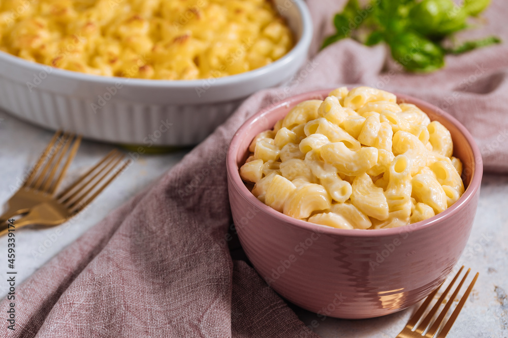 Mac and cheese with basil on top on a rustic wooden board Mac and cheese with basil on top on a rustic wooden board