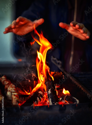 A man warms his hands over a fire