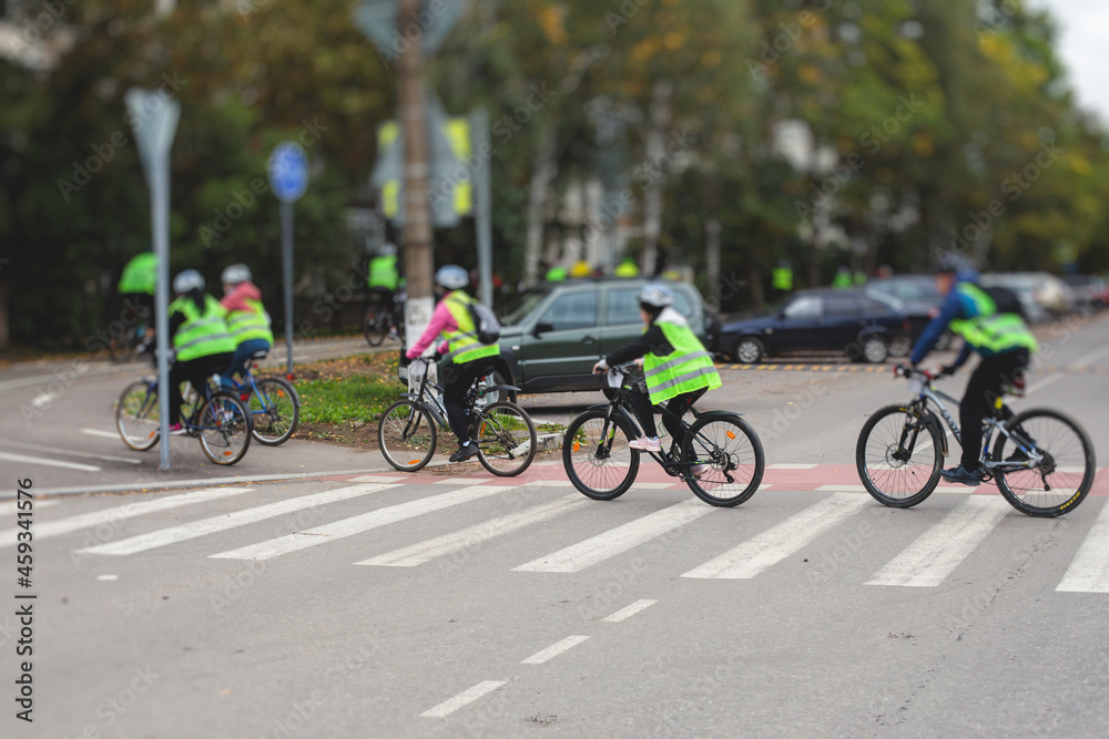 View of bicycle race in the city streets, bike race with a group mass of cyclist athletes in cycling competition, team of bikers on a urban bike path View of bicycle race in the city streets, bike race with a group mass of cyclist athletes in cycling competition, team of bikers on a urban bike path