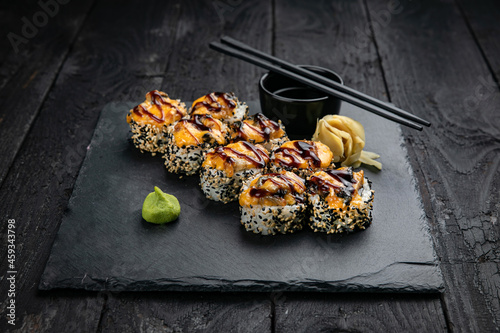Japanese cuisine. Rolls on a square plate on a black table 