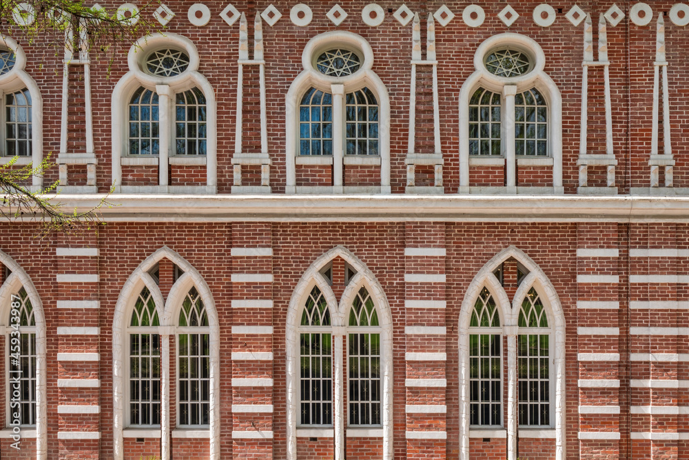 Fototapeta premium Brick wall of an old 18th century building with large windows.