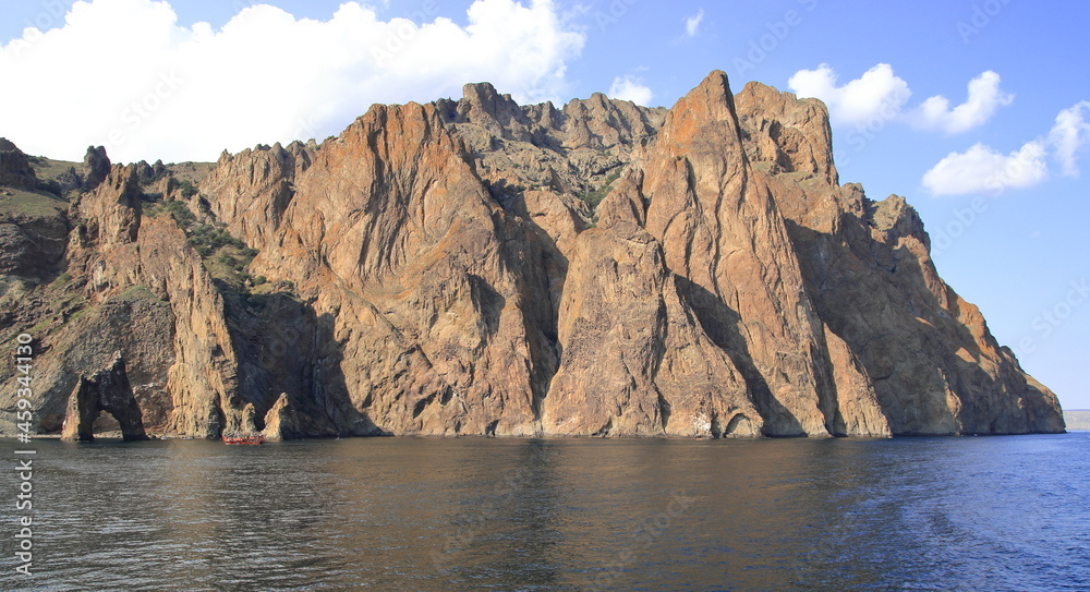 Naklejka premium The cliffs of a high mountain on the seashore, calm and clear weather. Suitable for backgrounds, photo wallpapers and landscape lovers.