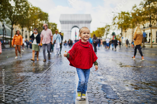 Happy preschooler girl walking in Champs-Elysees in Paris, France photo