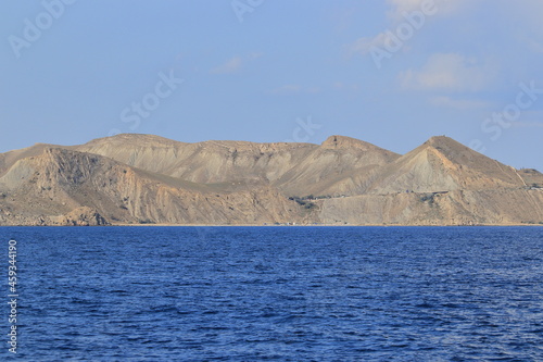 The seashore in sunny weather, a view of the cape and a calm sea. Suitable for photo wallpapers, photo frames and lovers of water landscapes.