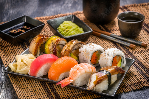 Assorted Sushi on Bamboo Mat with Saki photo