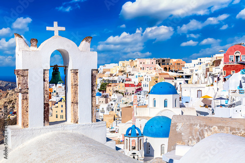 Oia village with famous white houses and blue churches on Santorini island, Aegean sea, Greece.