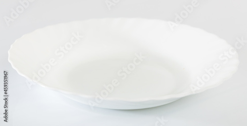 Closeup of clean empty white porcelain plate on white table surface, mock up