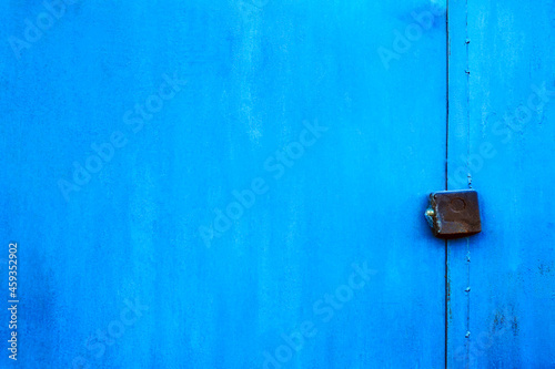 Blue old door. Metal blue door with padlock. Old garage gates