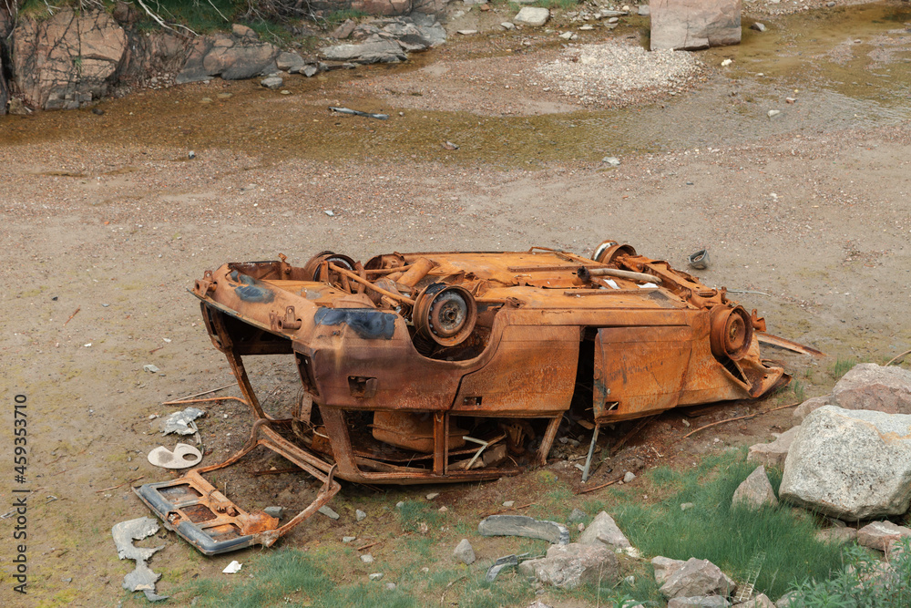 Fototapeta premium Rusty, overturned car. A car abandoned after an accident.