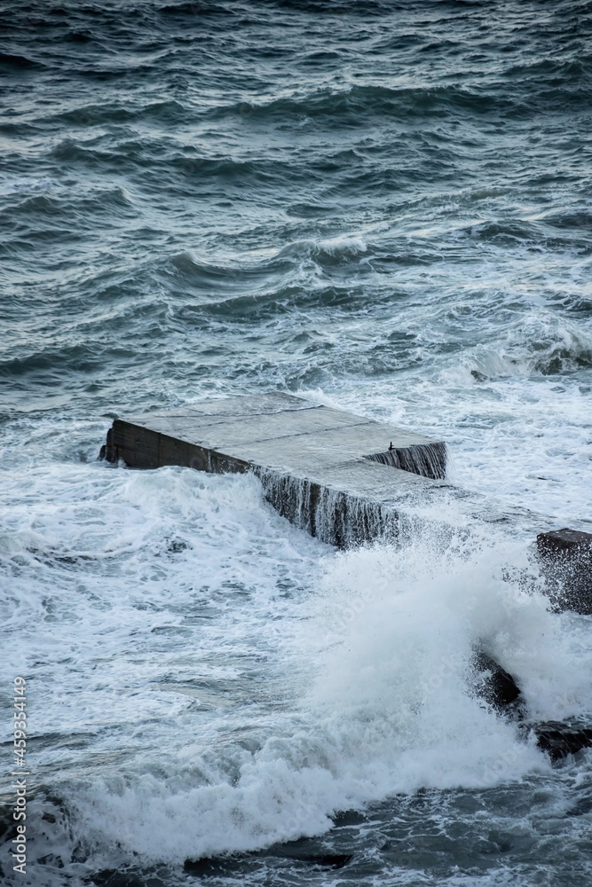 Fototapeta premium Sea waves break on a concrete pier. Breakwater.