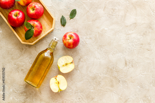 Fotografie Homemade apple cider vinegar in glass bottle with red apples