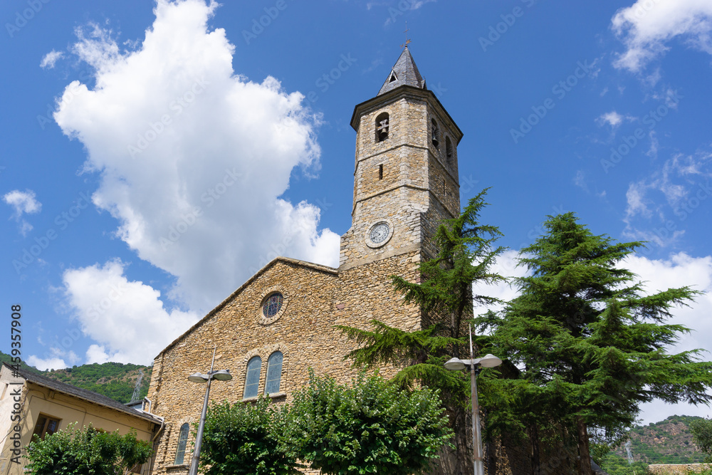 View of the stone church of the town of Sort on a sunny day with clouds