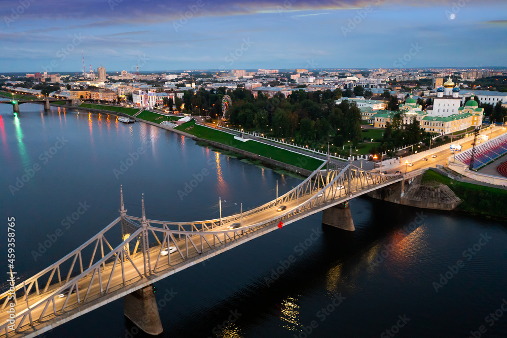 Summer aerial view of modern Tver cityscape overlooking Transfiguration Cathedral and Imperial Traveling Palace on bank of Volga river at dusk, Russia