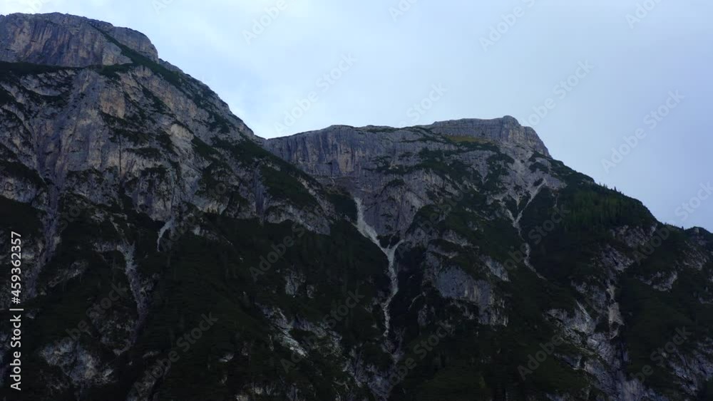 Dolomites, Three Peak National Park, South Tyrol, Italy, September 2021. Drone gradually tracks parallel to the steep cliff-sides. Dolomites, Three Peak National Park, South Tyrol, Italy, September 2021. Drone gradually tracks parallel to the steep cliff-sides.