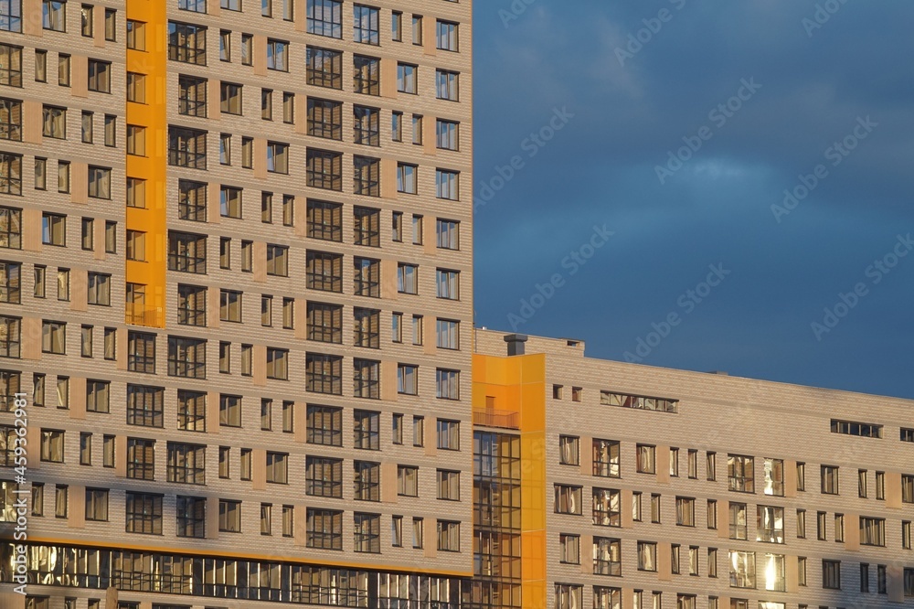 Horizontal full-color photo. Urban texture. Glass and concrete with reflections in the evening light.