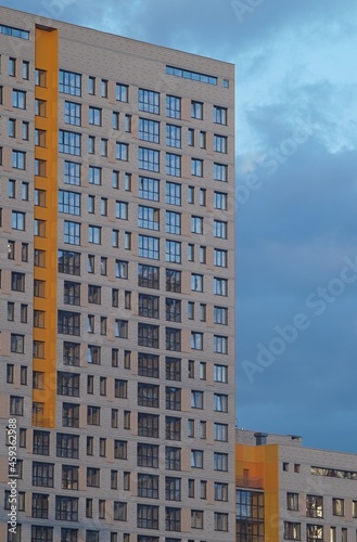 Horizontal full-color photo. Urban texture. Glass and concrete with reflections in the evening light.