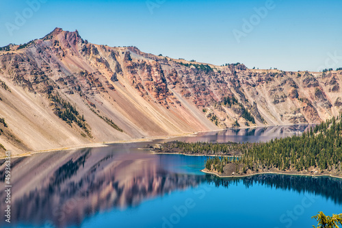 Blue lake in the mountains with large volcanic cinder cone island.