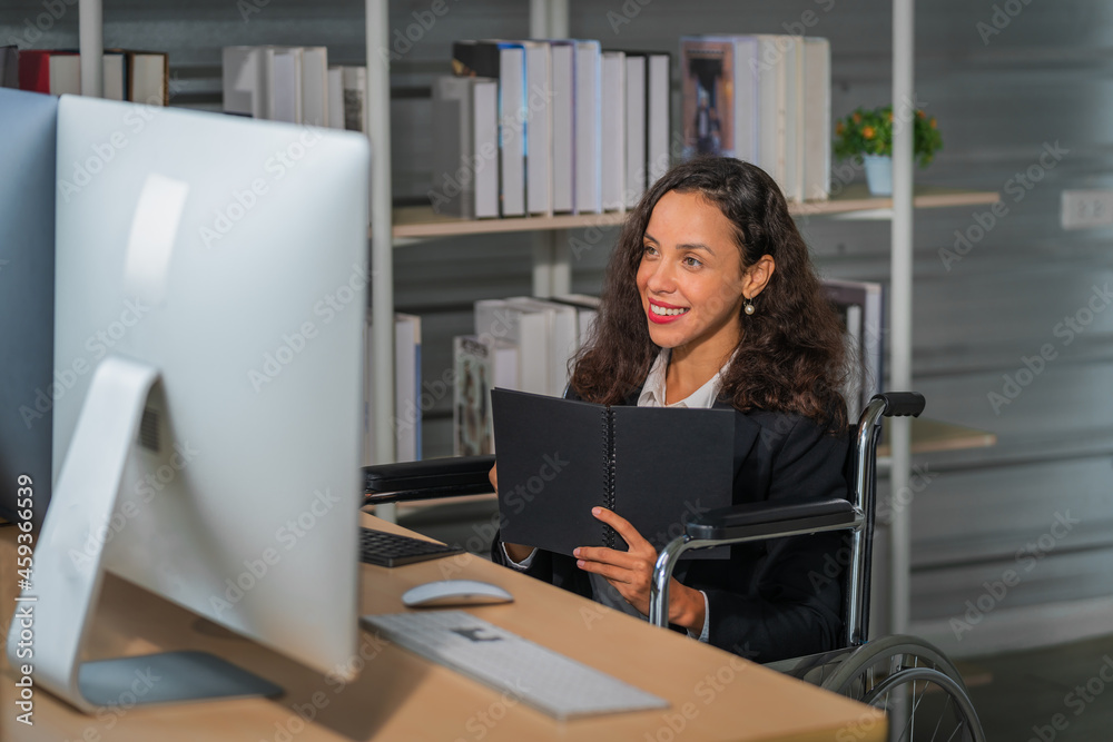 female disabled executive management on wheelchair working in office female disabled executive management on wheelchair working in office