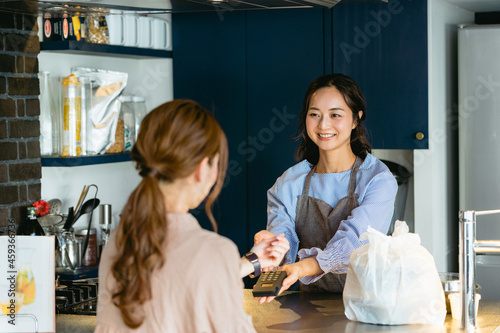 カフェ（飲食店）でスマートウォッチ決済をする女性