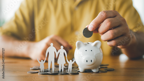Canvas-taulu businessman putting coin on the piggybank and paper family on table, donation, saving, charity, family finance plan concept, fundraising, superannuation, investment, financial crisis concept