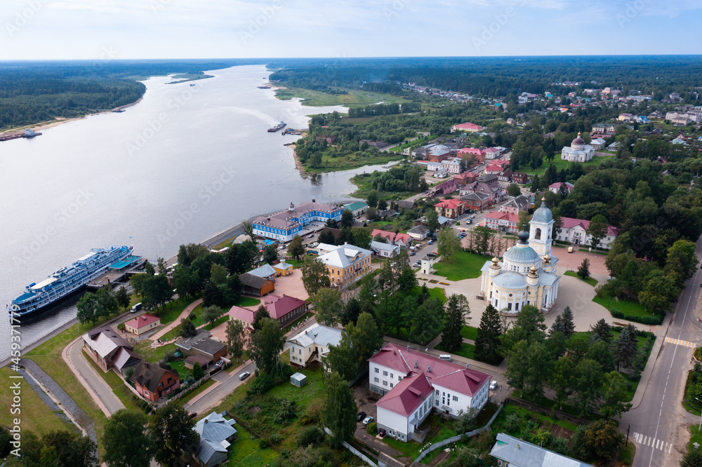 Scenic summer view from drone of ancient town of Myshkin located on steep left bank of Volga overlooking modern river station and medieval temples, Russia..