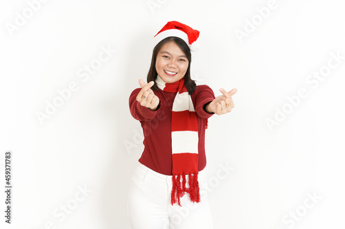 Showing Korean Heart Finger of Beautiful Asian Woman Wearing Red Turtleneck and Santa Hat Isolated On White Background