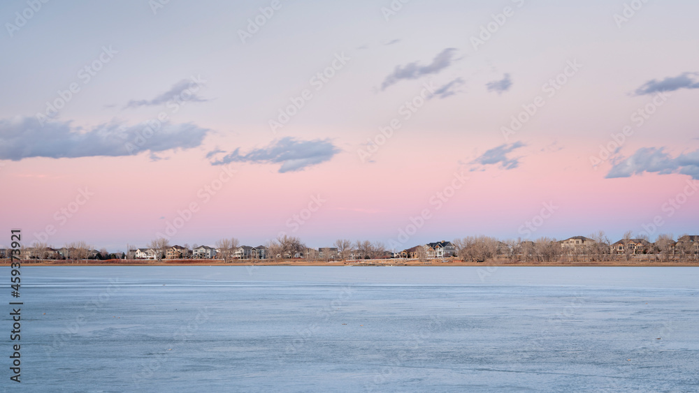 frozen lake after sunset with houses at waterfront - Boyd Lake in northern Colorado