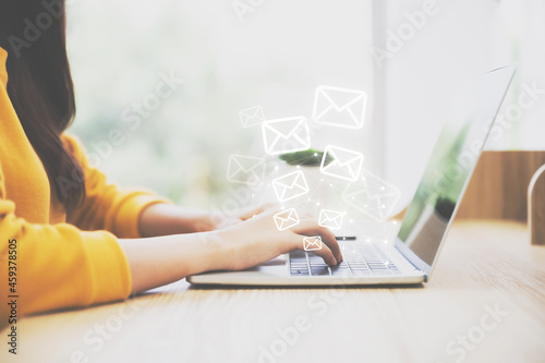 Woman hand using computer laptop pc with email icon. Concept of email and contact us photo