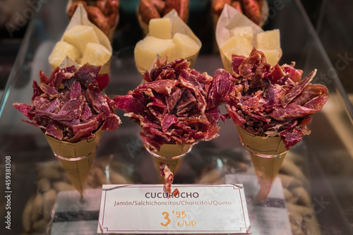 Cones or cucurucho pintxos or tapas with Spanish serrano iberico ham carvings, sausage and cheese pieces at a local butcher shop in Pamplona Spain photo