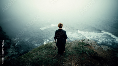 a samurai girl stands on a cliff