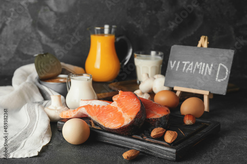 Different healthy products with vitamin D on dark background