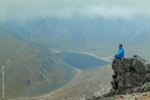 A middle aged backpacker looking over the Quilotoa volcanic crater lagoon