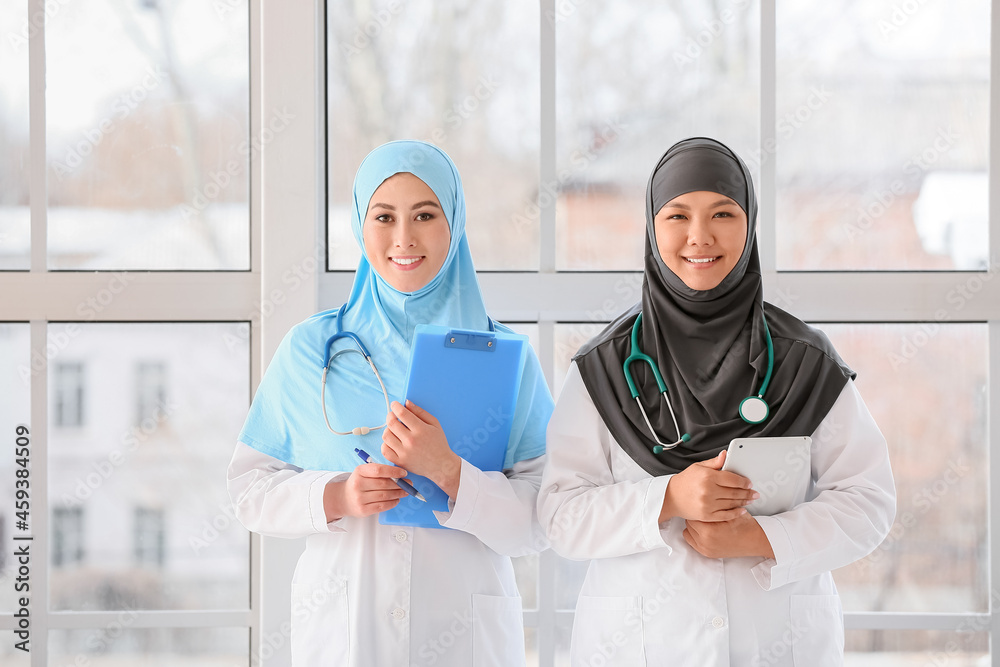 Muslim female doctors near window in clinic