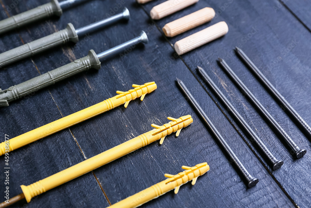 Wood screws, nails and dowels on color wooden background, closeup Wood screws, nails and dowels on color wooden background, closeup