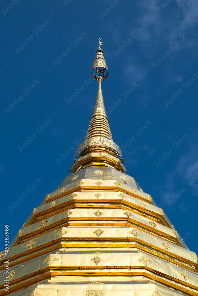 Low angle view of golden pagoda against clear blue sky