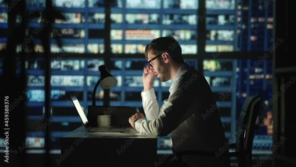 Closeup tired man working late with laptop at home office. Businessman Tired of work Looking on Laptop. Workaholic Work In Internet Deadline Closeup tired man working late with laptop at home office. Businessman Tired of work Looking on Laptop. Workaholic Work In Internet Deadline