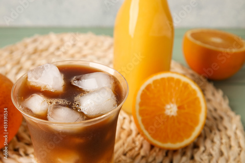 Glass of tasty coffee with orange juice on table, closeup