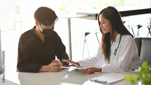 Male patient visiting female doctor to checkup his sickness symptoms