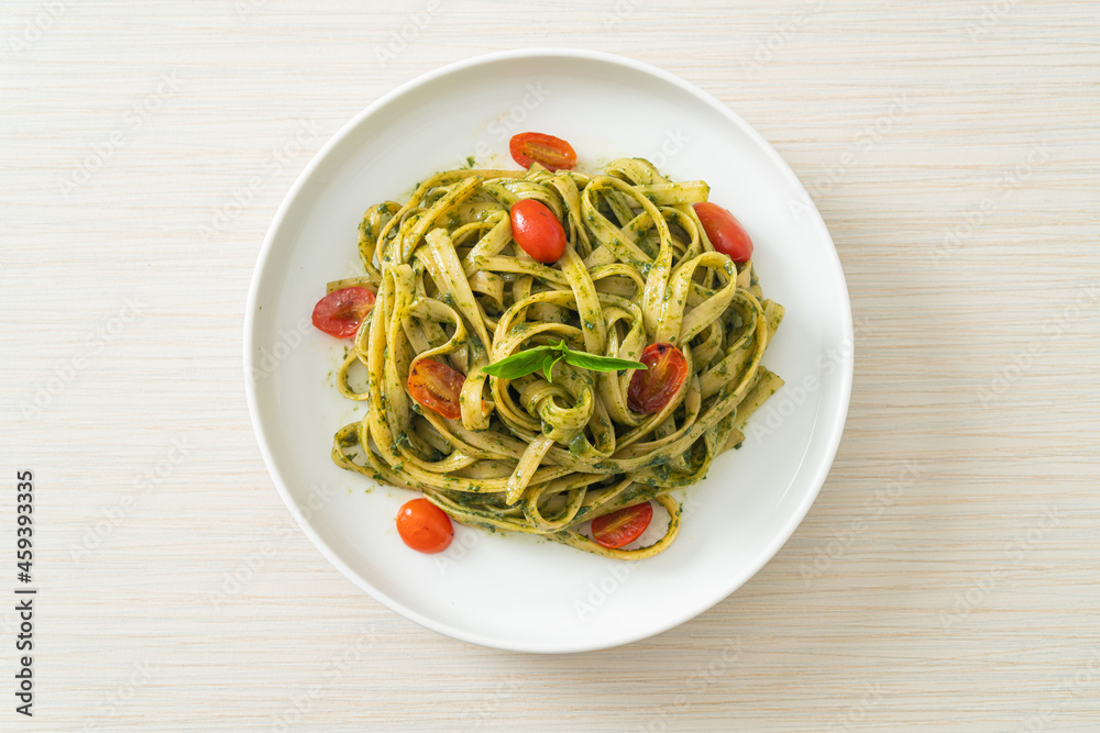 fettuccine spaghetti pasta with pesto sauce and tomatoes
