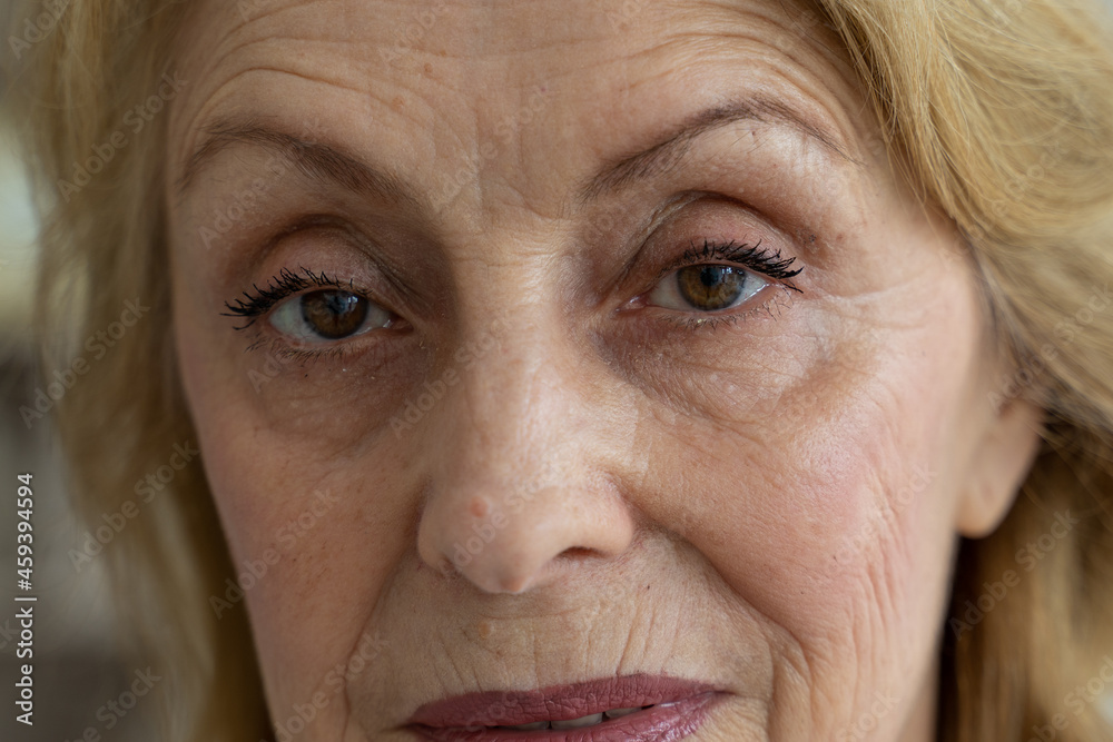The eyes of an elderly woman look at the camera in close-up
