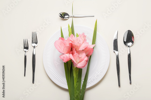 Gorgeous gladiolus flowers and table setting on light background