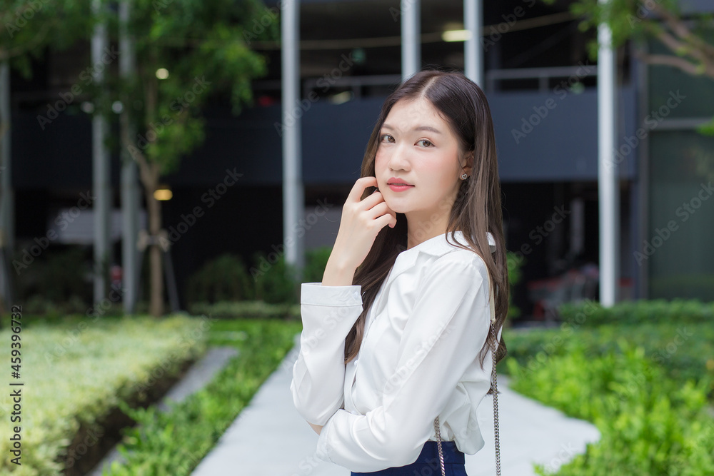 Asian businesswoman wearing a white shirt and smiling while working outside the office Asian businesswoman wearing a white shirt and smiling while working outside the office