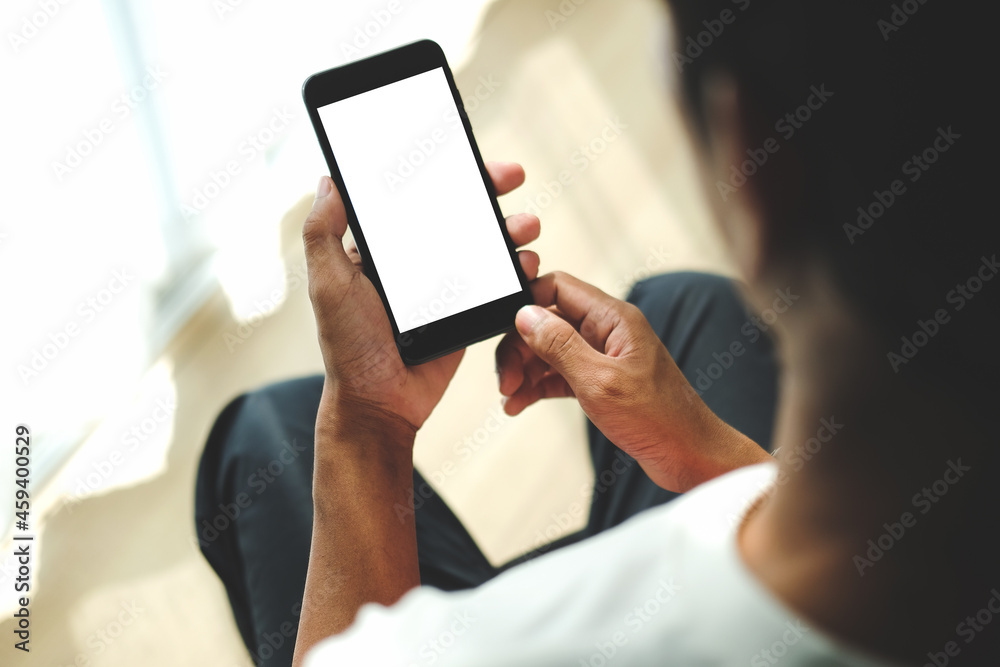 Young man sitting in living room and using smart phone. Young man sitting in living room and using smart phone.