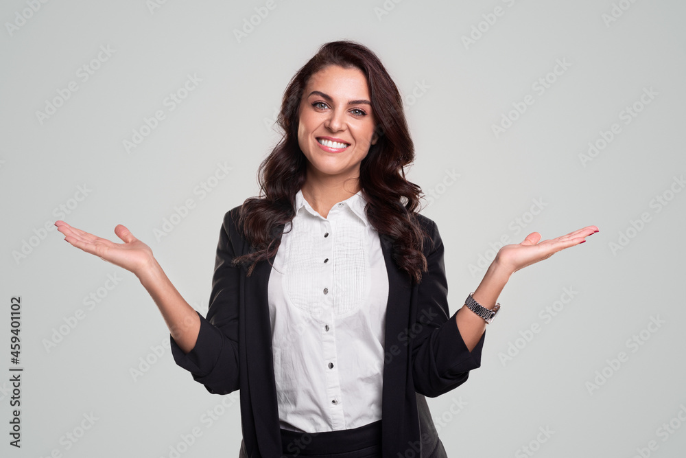 Cheerful businesswoman pointing aside and looking at camera Cheerful businesswoman pointing aside and looking at camera