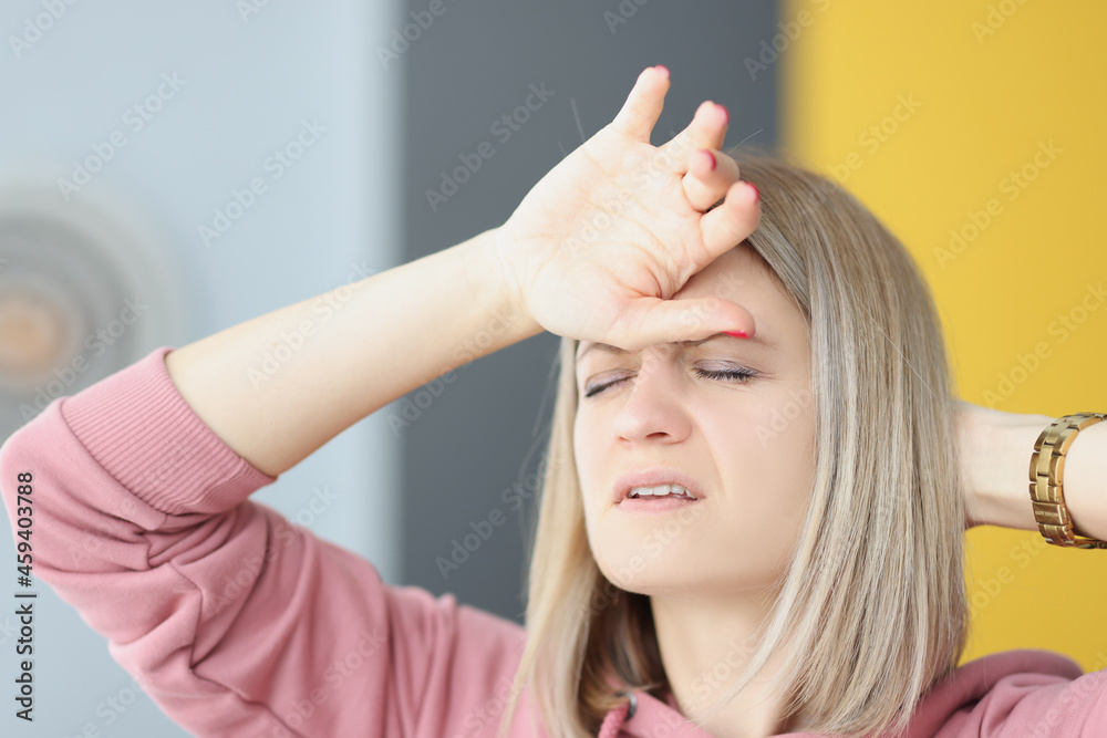 Fototapeta premium Portrait of young tired woman with headache closeup