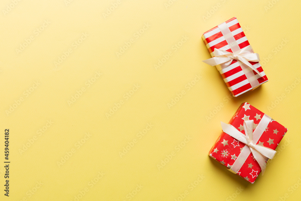 Holiday flat lay with gift boxes wrapped in colorful paper and tied decorated with confetti on colored background. Christmas, Birthday, Valentine and sale concept, top view Holiday flat lay with gift boxes wrapped in colorful paper and tied decorated with confetti on colored background. Christmas, Birthday, Valentine and sale concept, top view
