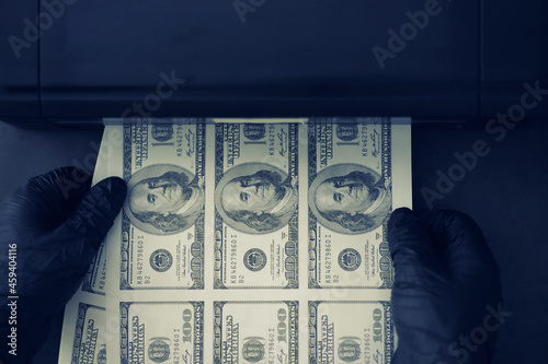 The concept of the global economic crisis. Illegal production of US dollars. Print money underground. Printing hundred dollar bills by a criminal.
