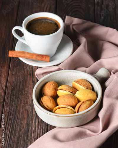 Walnut shaped cookies with caramel and walnuts Georgian cookies Oreshki served in a traditional bowl with cup of coffee