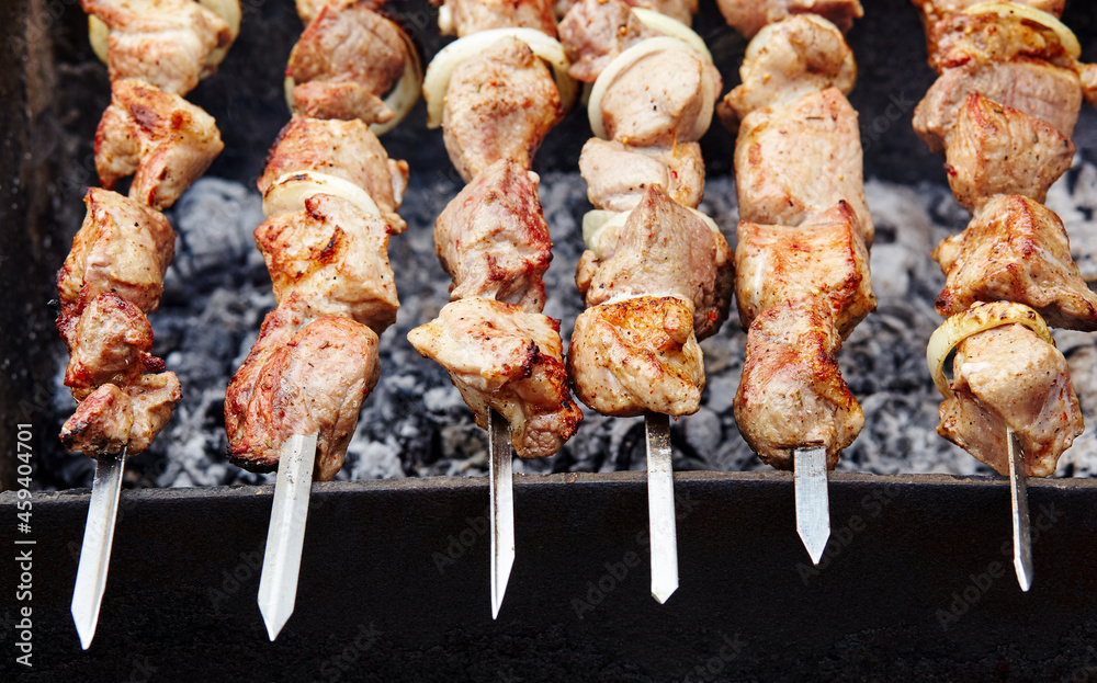 Marinated shashlik preparing on a barbecue grill over charcoal. Traditional Russian shashlik on a barbecue skewer Marinated shashlik preparing on a barbecue grill over charcoal. Traditional Russian shashlik on a barbecue skewer